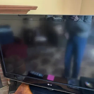 Sale Photo Thumbnail #289: Black LG flat-screen television on a swivel base, accompanied by a remote control.