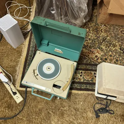 Sale Photo Thumbnail #97: Vintage General Electric portable turntable record player in a turquoise plastic case, mid-20th century.