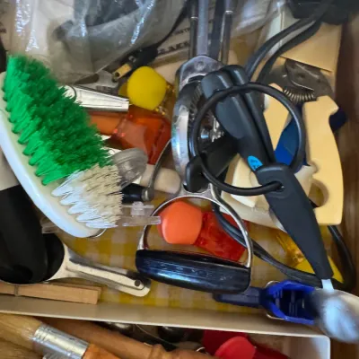 Sale Photo Thumbnail #252: Kitchen drawer filled with miscellaneous gadgets and tools, including scrub brushes, hand mixers, and basting brushes.