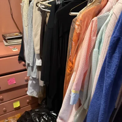 Sale Photo Thumbnail #151: Closet rod packed with a variety of women's clothing, robes, and garments on plastic and metal hangers.
