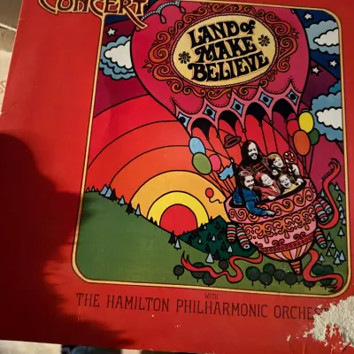 Sale Photo Thumbnail #2: Chuck Mangione vinyl record, "Land of Make Believe," released in 1973 featuring psychedelic album art. Shows noticeable wear and tearing along the bottom right edge of the sleeve.