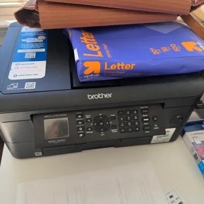 Sale Photo Thumbnail #220: Brother MFC-J1010DW Work Smart Series wireless all-in-one inkjet printer, topped with a ream of Up&Up letter printer paper.