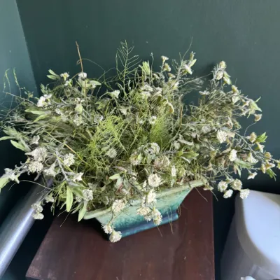 Sale Photo Thumbnail #276: Dried floral arrangement in a vintage ceramic planter displayed on a small dark wood accent table.