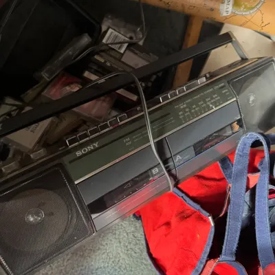 Sale Photo Thumbnail #128: Vintage Sony dual-cassette boombox with AM/FM radio tuner, displaying light surface wear from age and use.