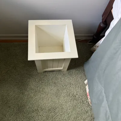 Sale Photo Thumbnail #104: White painted wooden planter box or decorative trash bin with wainscoting-style side panels, sitting on green carpeting.