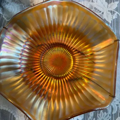 Sale Photo Thumbnail #65: Vintage marigold carnival glass bowl featuring a ribbed pattern, ruffled edge, and iridescent finish.