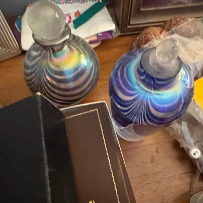 Sale Photo Thumbnail #23: Pair of vintage iridescent art glass perfume bottles featuring swirl patterns and clear glass stoppers.