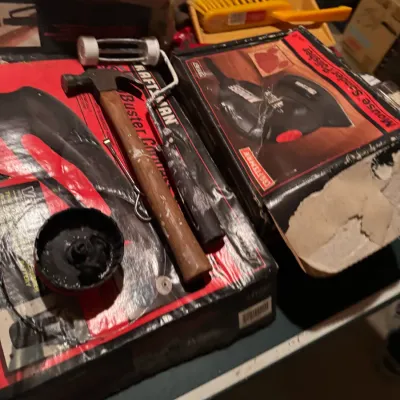 Sale Photo Thumbnail #88: Assortment of household tools and equipment, including a boxed Craftsman Mouse sander polish, a wooden-handled claw hammer, a mini paint roller, and a yellow dustpan set.