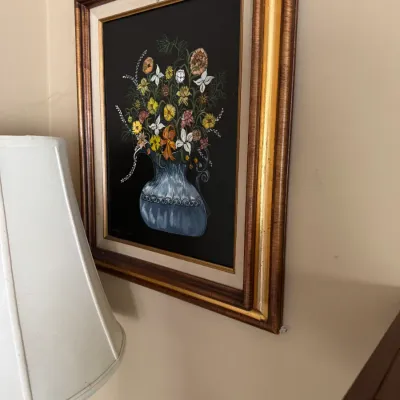 Sale Photo Thumbnail #286: Framed floral still life painting on a dark background, featuring colorful wildflowers in a blue ceramic vase, set in an ornate wood and gilt frame.