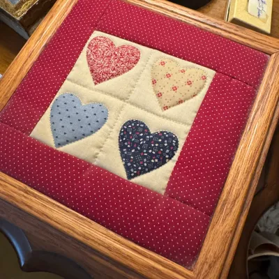 Sale Photo Thumbnail #172: Handmade wooden keepsake box featuring a quilted fabric insert on the lid with appliqué heart motifs in a country folk art style.