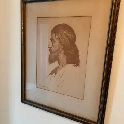 Sale Photo Thumbnail #145: Framed profile portrait illustration of Jesus, rendered in sepia tones, set under glass in a dark wooden frame with gold trim.