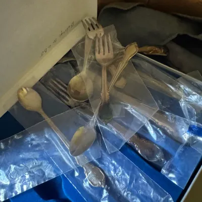 Sale Photo Thumbnail #361: Collection of vintage tarnished silverware pieces, including forks and spoons, stored in individual plastic sleeves within a storage box.