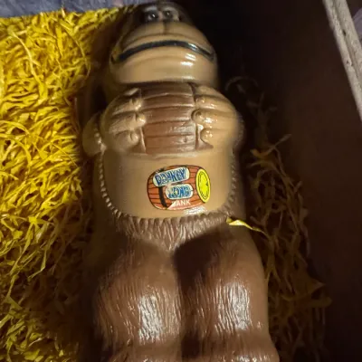 Sale Photo Thumbnail #4: Vintage 1981 Nintendo Donkey Kong plastic coin bank, featuring the iconic ape holding a barrel with original label attached.