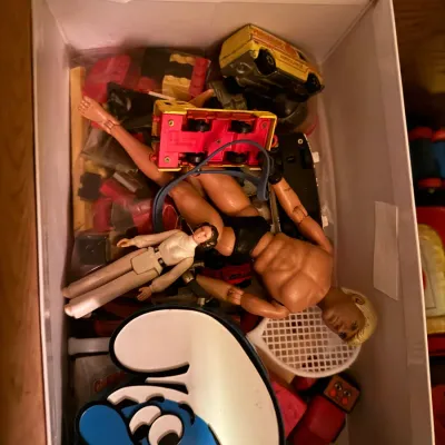 Sale Photo Thumbnail #5: Shoebox containing vintage toys, including a GI Joe action figure, a vintage Star Wars Princess Leia figure, a Smurf lunchbox, and various die-cast vehicles.