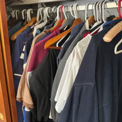 Sale Photo Thumbnail #125: Closet filled with men's clothing, including casual shirts, jackets, and sweaters hung on various wooden and plastic hangers.