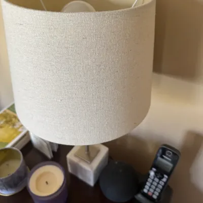 Sale Photo Thumbnail #284: Modern accent table lamp featuring a square marble base and a cylindrical beige linen drum shade.