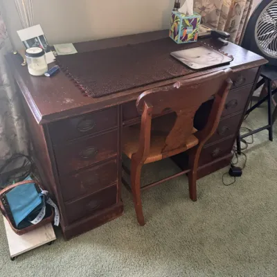 Sale Photo Thumbnail #108: Vintage dark stain wooden double-pedestal desk with brass bail handles, paired with a matching wooden side chair featuring a woven seat.