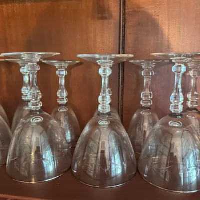 Sale Photo Thumbnail #397: Set of vintage etched crystal wine glasses stored upside down inside a wooden hutch cabinet.