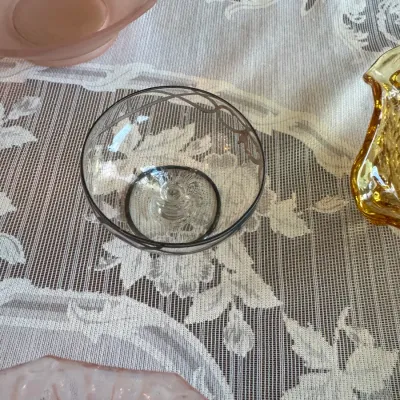 Sale Photo Thumbnail #413: Vintage clear glass bowl featuring silver overlay floral motifs and trim, shown alongside other art glass pieces on a lace tablecloth.