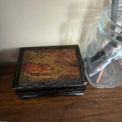 Sale Photo Thumbnail #313: Vintage Russian lacquer trinket box featuring a hand-painted scene on the lid, displayed alongside a clear glass mason jar.