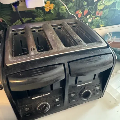 Sale Photo Thumbnail #261: Hamilton Beach four-slot toaster in black and brushed metal finish, showing light surface dust and signs of use.