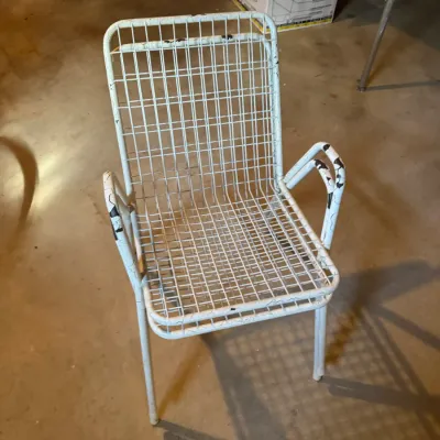 Sale Photo Thumbnail #76: Vintage white painted wrought iron grid patio armchair showing paint chipping and wear.