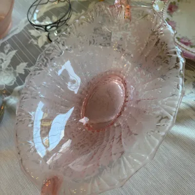 Sale Photo Thumbnail #63: Vintage pink depression glass handle serving dish featuring an etched floral motif and scalloped edges.