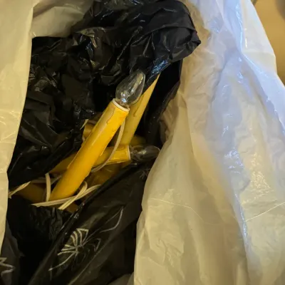 Sale Photo Thumbnail #356: Collection of vintage yellow plastic window candle lights packed in bags with white electrical cords and flame-shaped bulbs.