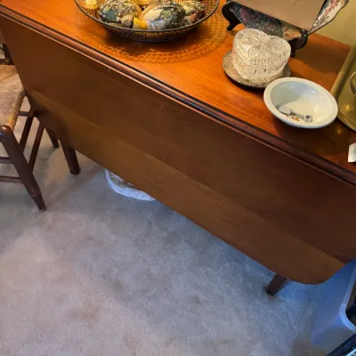Sale Photo Thumbnail #340: Mid-century wooden drop-leaf sofa table or server, topped with decorative glass orbs, a cut crystal heart-shaped box, and small tableware.