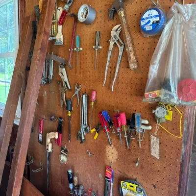 Sale Photo Thumbnail #201: Pegboard wall organization filled with assorted vintage and modern hand tools, including hammers, pliers, screwdrivers, and hardware.