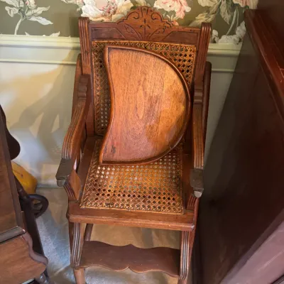 Sale Photo Thumbnail #390: Antique carved oak high chair featuring a woven cane backrest and seat, complete with a detachable wooden tray.