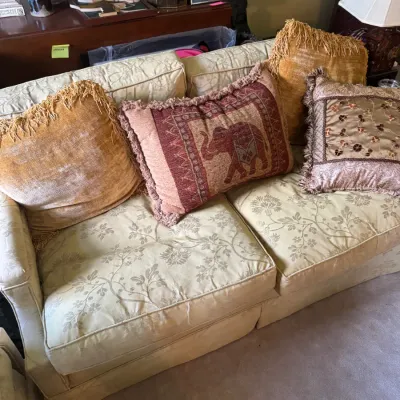 Sale Photo Thumbnail #362: Cream damask floral sofa styled with an assortment of fringed decorative throw pillows.