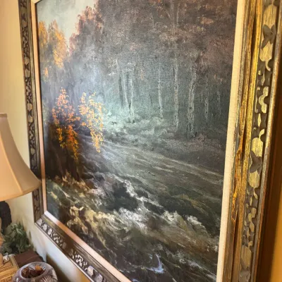 Sale Photo Thumbnail #347: Large vintage framed oil painting depicting a forest landscape with a rushing river, signed by the artist in the lower right corner.