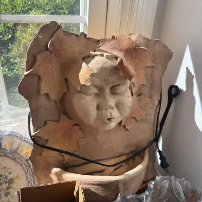 Sale Photo Thumbnail #27: Handcrafted ceramic wall fountain depicting a child's face surrounded by autumn maple leaves.