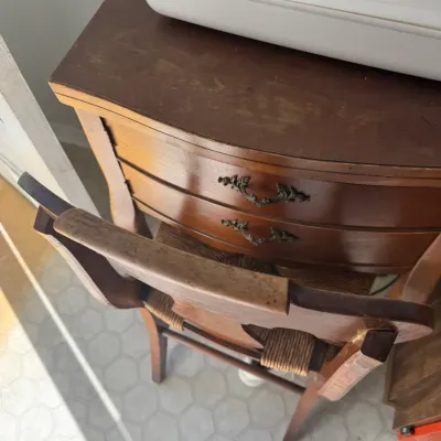 Sale Photo Thumbnail #221: Vintage dark wood sewing machine cabinet with decorative metal drawer pulls, paired with a matching ladder-back chair featuring a woven rush seat.