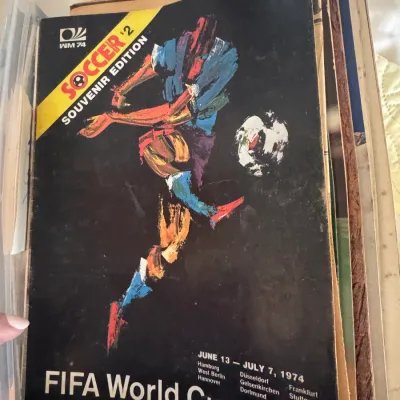 Sale Photo Thumbnail #19: Vintage 1974 FIFA World Cup Soccer souvenir edition program, featuring artistic cover graphics and showing age-appropriate wear along the edges.