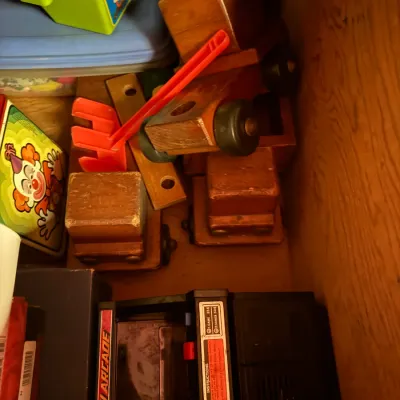 Sale Photo Thumbnail #93: Collection of vintage toys including handmade wooden vehicles, a vintage Fisher-Price plastic set, and an 1980s Mini Arcade tabletop game.