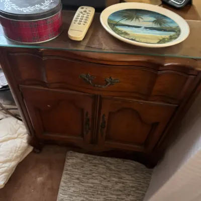 Sale Photo Thumbnail #187: French Provincial style dark wood nightstand with a glass top, single drawer, and lower cabinet storage.