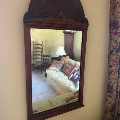 Sale Photo Thumbnail #372: Vintage dark wood wall mirror featuring an arched top crest with carved scrollwork details.