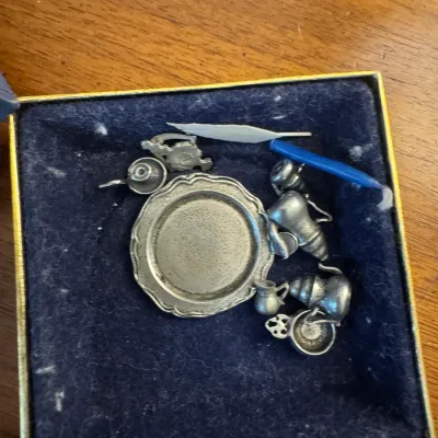 Sale Photo Thumbnail #170: Miniature pewter tea set and accessories arranged inside a felt-lined presentation box.