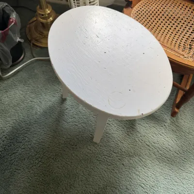 Sale Photo Thumbnail #140: Small oval wooden accent table painted white, showing light surface wear and faint cup rings.