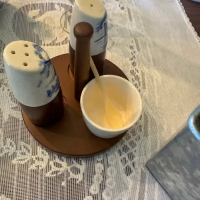 Sale Photo Thumbnail #410: Vintage ceramic and wood condiment set featuring Dutch windmill blue and white salt and pepper shakers, a mustard pot with spoon, and a fitted wooden caddy.