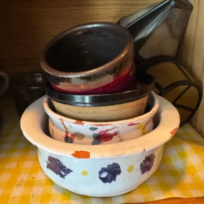 Sale Photo Thumbnail #237: Stacked set of hand-painted and glazed ceramic bowls stored inside a wooden cabinet.