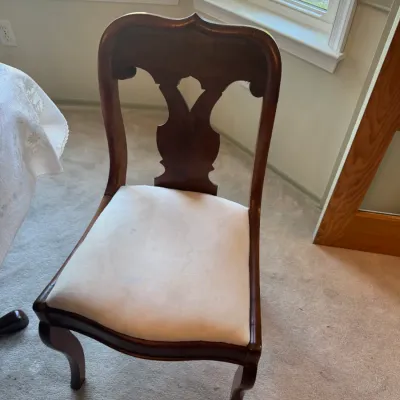 Sale Photo Thumbnail #376: Antique mahogany dining chair featuring a carved balloon-back design, vasiform splat, cabriole legs, and a cream-colored upholstered slip seat.