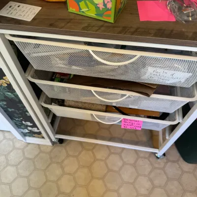 Sale Photo Thumbnail #249: White metal wire mesh rolling storage cart with a wood-look top surface.
