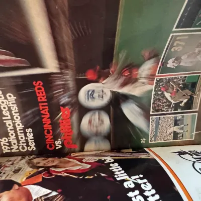 Sale Photo Thumbnail #156: Official program for the 1976 National League Championship Series featuring the Cincinnati Reds vs. Philadelphia Phillies, displaying full-color photo illustrations and advertisements.