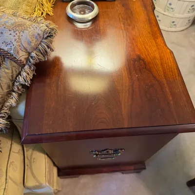 Sale Photo Thumbnail #351: Traditional dark wood end table featuring a brass bail handle and visible surface scratches from use.