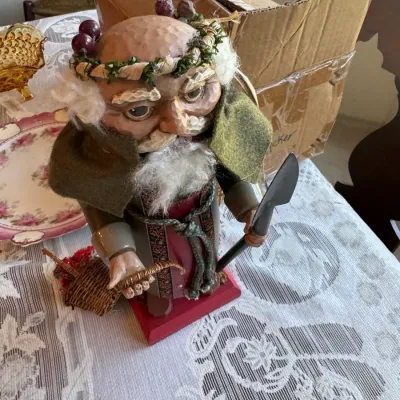 Sale Photo Thumbnail #411: Hand-carved wooden Santa figure depicting Bacchus or the Ghost of Christmas Present, featuring a berry wreath, felt cape, and spade accessory.