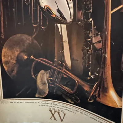 Sale Photo Thumbnail #158: Official Super Bowl XV game program cover print from January 25, 1981, featuring the Vince Lombardi Trophy surrounded by musical instruments.