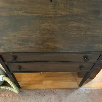 Sale Photo Thumbnail #176: Vintage dark stain wooden slant-front secretary desk with two lower drawers and wooden knobs.
